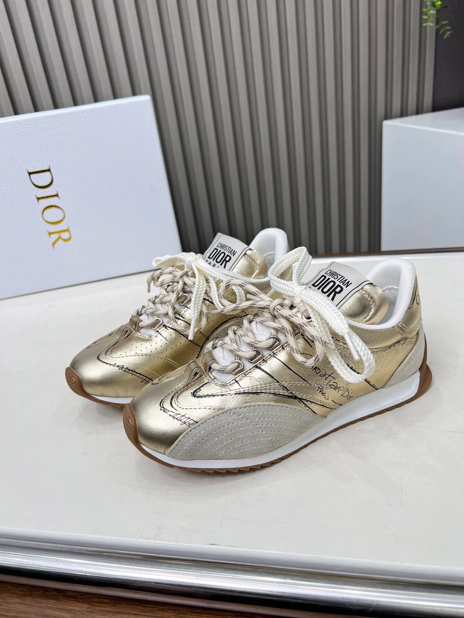 👟👟Ex-factory price 560👟👟 This D-Sketch sneaker is a new product of the 2025 spring and summer ready-to-wear series, highlighting the classic retro aesthetics. Crafted from gold-tone crinkled sheepskin and gold-toned laminated calfskin, it features a printed logo inspired by the shoe's production stages, as well as beige suede calfskin panels and double laces. Hand-written Christian Dior Paris signature on the side, Christian Dior Paris signature panels and plaques on the heel and tongue. Paired with two-tone slim rubber soles, they add a touch of couture to any casual look. Code number: 35~45 Color: black white gold silver